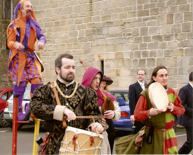 Medieval jester and musicians entertain at a wedding